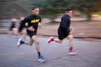 Army soldier runs up hill.
