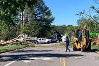A man carries a piece of furniture through a neighborhood in Virginia Beach, Va. The City of Virginia Beach declared a state of emergency after a tornado moved through the area and damaged dozens of homes, downed trees and caused gas leaks. 
