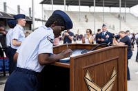 Airman 1st Class D'elbrah Assamoi signs her U.S. certificate of citizenship.