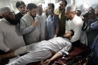 People transport an injured victim at a hospital in Peshawar, Pakistan.