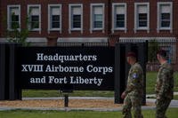 Soldiers walk past a newly unveiled sign after a redesignation ceremony officially renaming the military installation Fort Liberty