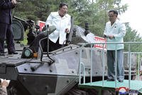North Korean leader Kim Jong Un, center, rides on an armored vehicle