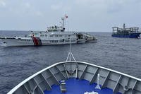 A Chinese coast guard ship, left, with a Chinese militia vessel blocks Philippine coast guard ship
