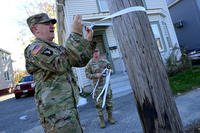 Soldiers from the Lewiston Recruiting Station tie ribbons to poles