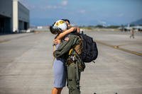 U.S. Navy Lt. Kaleb McConaghy, an F-18 pilot with Carrier Air Wing 5, hugs his spouse