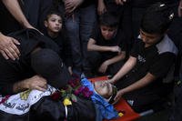 Relatives mourn over the body of a Palestinian man.