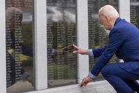 Joe Biden reaches to touch the name of his uncle Ambrose J. Finnegan, Jr., Scranton war memorial