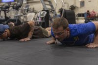U.S. Marines with the 31st Marine Expeditionary Unit and U.S. Navy sailors assigned to the amphibious assault ship USS America (LHA-6) prepare to start a push-up competition aboard the USS America in the Pacific Ocean.