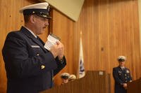 Master Chief Petty Officer Timothy Beard, off-going reserve command master chief, Coast Guard 13th District, displays the notes for the speech to the crowd during a change-of-watch ceremony in Seattle, July 9, 2018. (Petty Officer 3rd Class Amanda Norcross/U.S. Coast Guard photo)