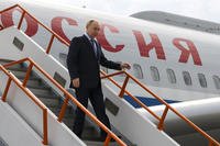 Russian President Vladimir Putin goes down the stairs upon his arrival at the airport of Yakutsk