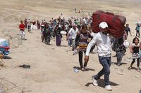 Syrian refugees cross into Iraq at the Peshkhabour border point in Dahuk