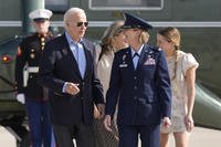 President Joe Biden is escorted by Air Force Col. Angela Ochoa, Commander, 89th Airlift Wing, as he arrives at Andrews Air Force Base