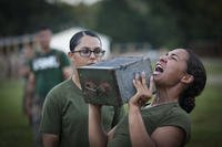 An officer candidate conducts the ammo can lift portion while another officer candidate counts the repetitions during the combat fitness test (CFT) at Marine Corps Officer Candidates School aboard Marine Corps Base Quantico, Virginia.