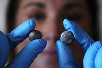 Museum curator Nikki Walsh holds up two Revolutionary War musket balls