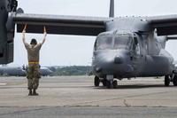 A U.S. Air Force crew chief marshals a CV-22B Osprey