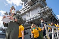 U.S. sailors assigned to the aircraft carrier USS Theodore Roosevelt (CVN 71) depart the ship