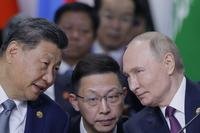 Chinese President Xi Jinping, left, and Russian President Vladimir Putin, right, speak