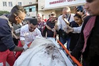 medic Abed Al Aziz Bardini cries over the body of his mother after he realizes it's her