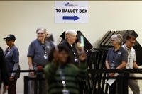 Poll workers wait to escort voters to the polling booths in Columbus