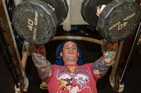 Culinary Specialist 1st Class Bennett Evans uses dumbbells for the bench press during a physical training session aboard Arleigh Burke-class guided-missile destroyer USS Dewey (DDG 105) in the East China Sea.