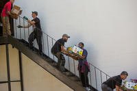 Members of American Legion Post 37 in Norfolk pass food boxes down a stairway