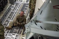 Chief Master Sgt. Stephen Moore, senior enlisted leader, 138th Space Control Squadron, Peterson Air Force Base, Colorado Air National Guard, secures equipment aboard a C-17 Globemaster.