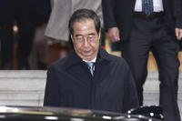 Impeached South Korean acting President Han Duck-soo leaves the government complex building in Seoul, South Korea