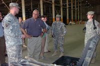 U.S. Army 1st Lt. Spencer Taylor, accountable officer for the forward redistribution point and attached to the 910th Quartermaster Company, briefs William Solis, the director of the U.S. Government Accountability Office, on operations at the corps distribution center at Joint Base Balad, Iraq.