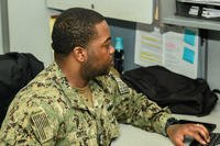 Yeoman 1st Class Mario Ortiz conducts a background check on a new sailor check-in onboard Naval Station Norfolk, Virginia.