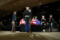 The Guard of Honor surrounds the flag-draped casket of former President Jimmy Carter.