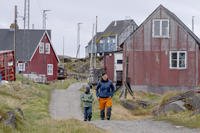 Local residents walk in the settlement Attu, in the Qeqertalik municipality, western Greenland
