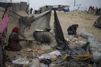 Mona Al-Zebda, displaced from Gaza City, bakes bread at a tent camp for displaced Palestinians