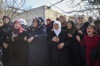 Relatives and neighbors mourn during a funeral procession.