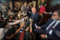 Philippine Ambassador to the U.S. Jose Romualdez, center, answers questions from reporters