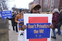 Protesters walk outside the John D. Dingell Veterans Affairs Medical Center in Detroit.