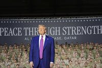President Donald Trump stands on stage at the Al Udeid Air Base