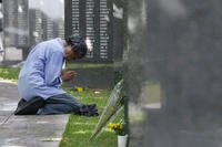 A bereaved person prays in front of the Cornerstone of Peace at the Peace Memorial Park in Itoman, Okinawa prefecture