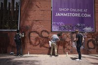 Volunteers remove graffiti from the Japanese American Museum