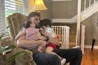 U.S. Marine Corps veteran Adrian Clouatre holds his 3-month-old daughter Lyn and his nearly two old son
