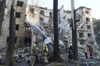 Firefighters work to extinguish a fire in an apartment building after a Russian attack in Kyiv, Ukraine