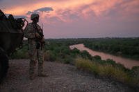 U.S. Army soldier stands beside a Stryker along the Rio Grande River
