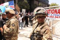 Members of the California National Guard keep an eye out as thousands participate in the &quot;No Kings&quot; demonstration in downtown Los Angeles