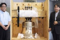 A church bell inside a shipping box.