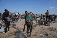 A Palestinian carries the body of a man killed while trying to receive aid