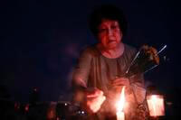 A visitor lights incense sticks at the Peace Memorial Park