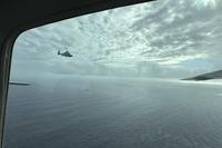 A Chinese military helicopter flies close to a Philippine Bureau of Fisheries and Aquatic (BFAR) aircraft above Scarborough shoal