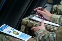 Service member writes in notebook.