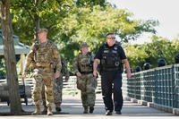 A Memphis Police Department officer patrols with members of the National Guard in Memphis, Tenn.