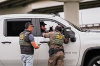 FILE - Customs and Border Patrol agents question occupants of a vehicle they pulled over, during an immigration crackdown in Kenner, La., Dec. 5, 2025. (AP Photo/Gerald Herbert, File)