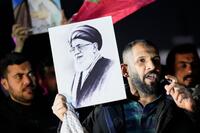 A protester holds a portrait of Iran's Supreme Leader Ayatollah Ali Khamenei.